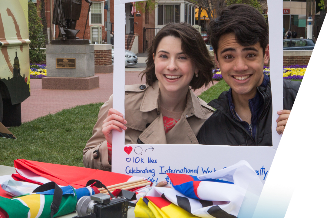 Male and female students posed with props on campus