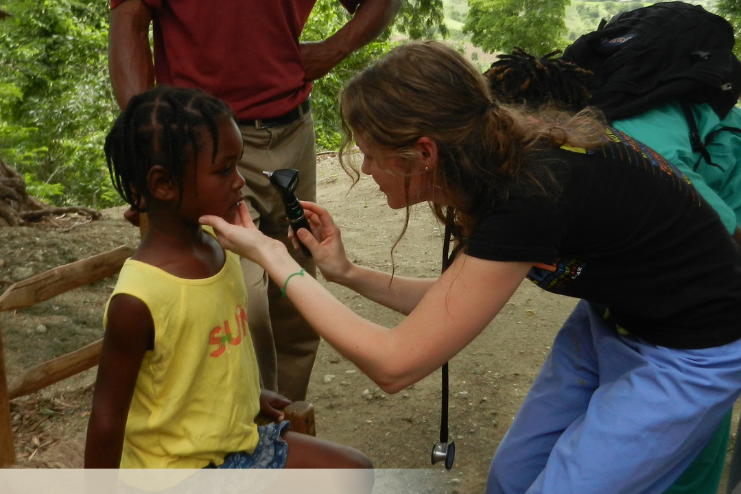 Medical student examining child's eyes